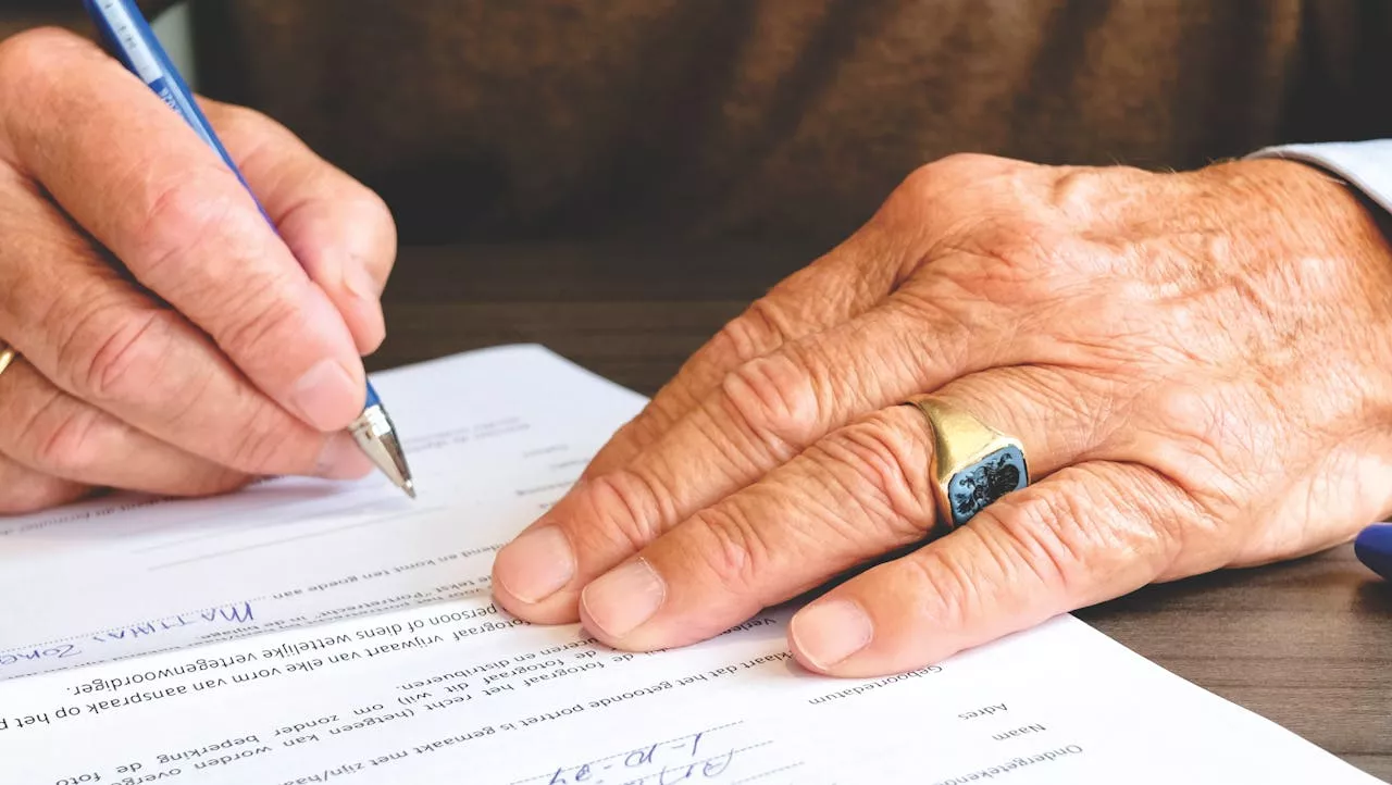 Man signing Florida living trust documents during an estate planning meeting to help avoid probate and protect family assets