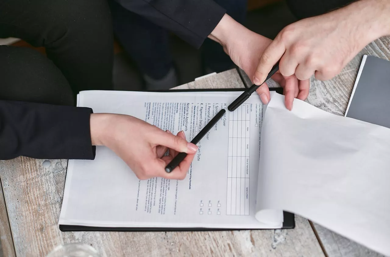 Person signing Florida trust and estate planning documents during a legal consultation about revocable and irrevocable trusts